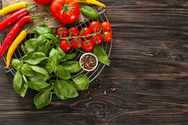 Baharatlar, fesleğen ve ahşap zemin üzerine domates ile kompozisyon