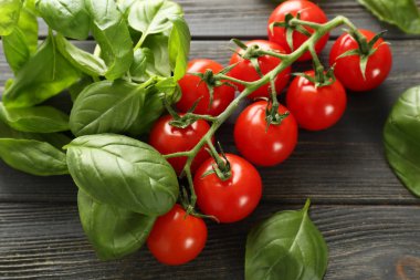 Ahşap zemin üzerinde taze fesleğen ve domates.