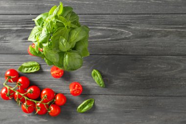 Ahşap zemin üzerinde taze fesleğen ve domates.