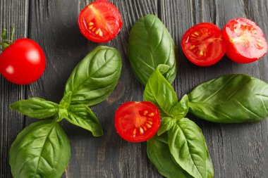 Ahşap zemin üzerinde taze fesleğen ve domates.