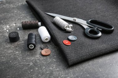 Kumaş ve dikiş aksesuarları koyu arka plan üzerinde