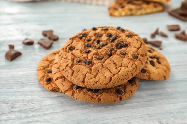 Beyaz ahşap zemin üzerinde çikolata parçaları ile lezzetli kurabiyeler