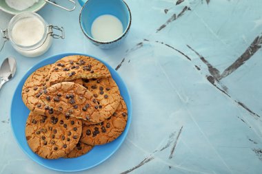 Çikolatalı kurabiye ve süt renkli arka plan üzerinde plaka