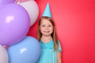 Balon renk arka plan üzerinde sevimli küçük kız. Doğum günü kutlaması