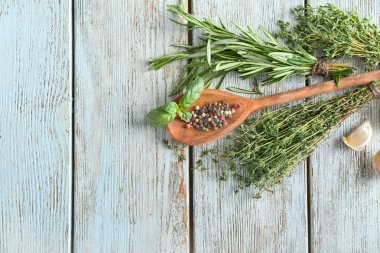 Farklı taze otlar, sarımsak ve baharat ahşap arka plan üzerinde
