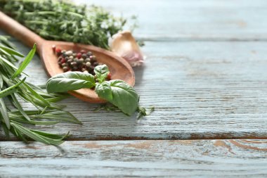 Farklı taze otlar ve baharatlar ahşap zemin üzerine kaşıkla