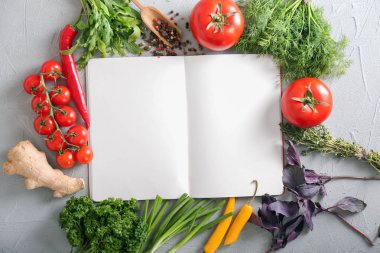 Boş defter, farklı taze otlar ve gri arka plan üzerinde sebze ile kompozisyon
