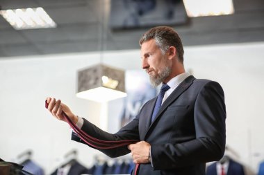 Olgun yakışıklı erkek giyim mağaza aksesuarları seçme