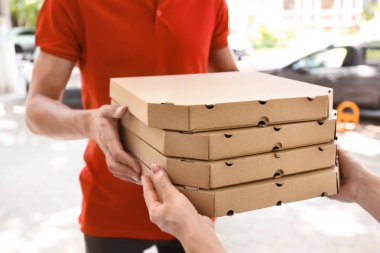 Genç kadın açık havada için veren pizza kutuları adam. Gıda dağıtım hizmeti