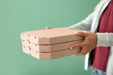 Pizza kutuları renk arka plan üzerinde olan genç adam. Gıda dağıtım hizmeti