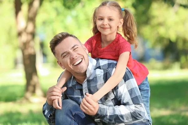 Happy father and daughter in green park