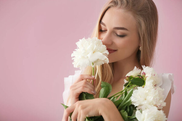 Attractive young woman with beautiful flowers on color background