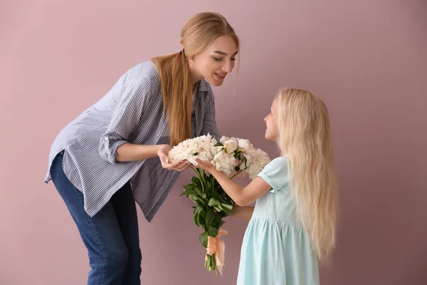 Cute Little Girl Giving Flowers Her Mother Color Background — Stock Photo, Image