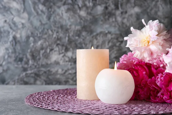 Brennende Kerzen Mit Blumen Auf Dem Tisch Vor Grauem Hintergrund — Stockfoto