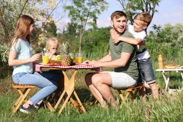 Happy family having lunch at table on summer picnic