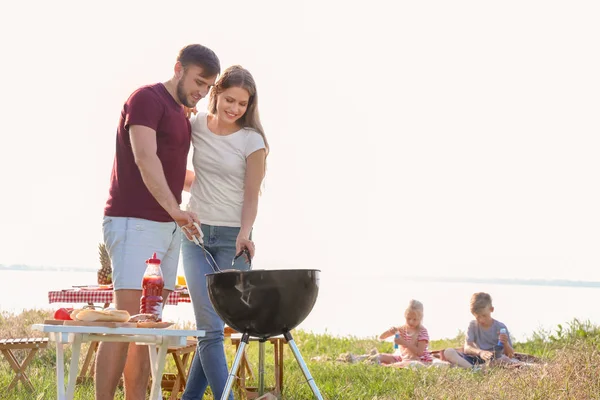 Feliz Casal Jovem Cozinhar Comida Saborosa Churrasqueira Livre Piquenique Familiar — Fotografia de Stock