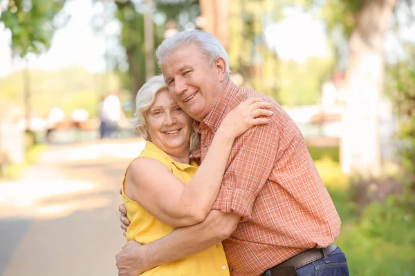 Happy mature couple in city park