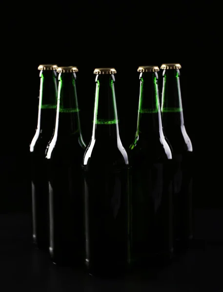 Glass bottles of cold beer on dark background