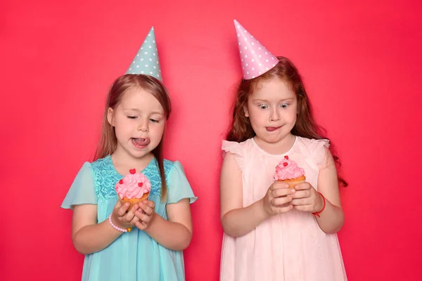 Lindas Niñas Con Gorras Cumpleaños Comiendo Cupcakes Fondo Color —  Fotos de Stock