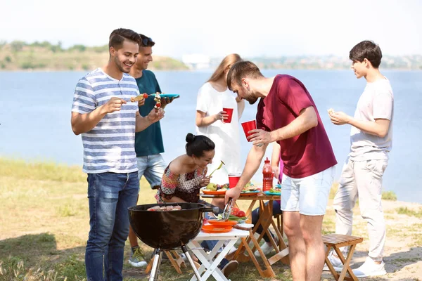 Young people having barbecue party on sunny day outdoors