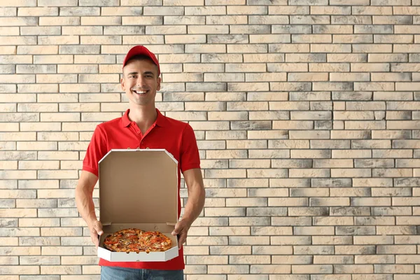 Mladý Muž Který Držel Box Chutnou Pizzu Proti Cihlové Zdi — Stock fotografie