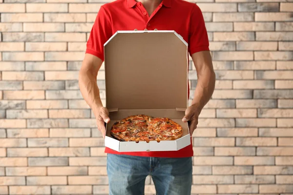 Młody Człowiek Przytrzymanie Pudełko Pysznej Pizzy Przed Mur Cegły Dostawa — Zdjęcie stockowe