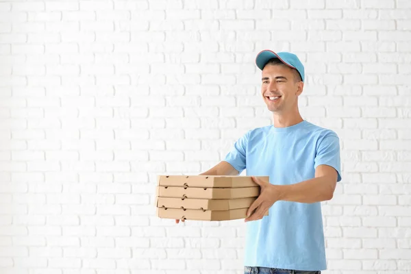 Junger Mann Mit Pizzakartons Gegen Weiße Backsteinmauer Essenslieferdienst — Stockfoto