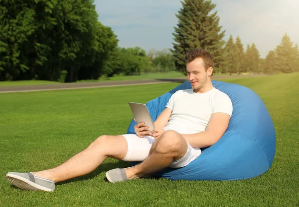 Ung Man Med Tablet Vilar Böna Väska Stol Utomhus — Stockfoto