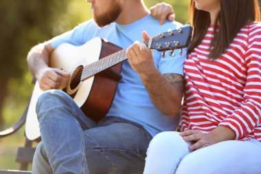 Mutlu çiftimiz parkta bahar gününde dinlenme gitar ile