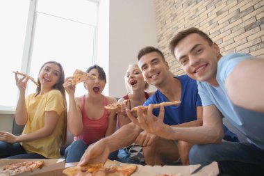 Selfie lezzetli pizza ile evde alan genç insanlar parti