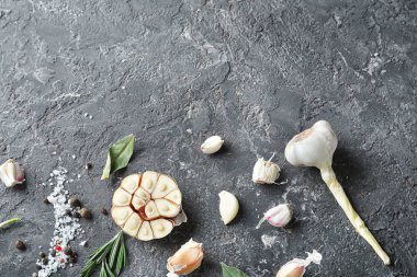 Gri dokulu arka plan üzerinde baharatlar ile taze sarımsak