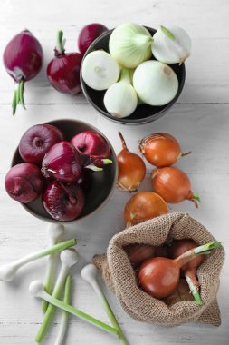 Beyaz ahşap zemin üzerinde farklı taze soğan