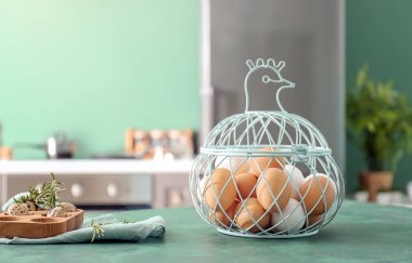 Mutfak masasının üstünde metal sepet tavuk ve yumurta