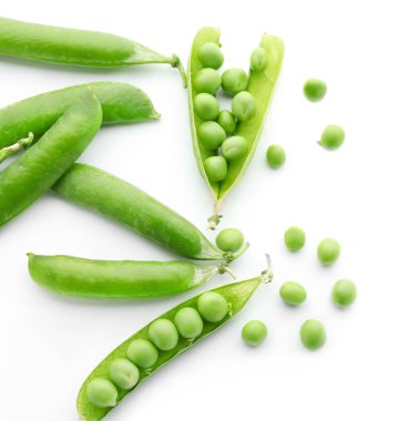 Beyaz arka plan üzerinde taze yeşil bezelye ile bakla