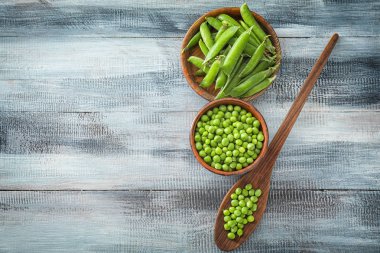 Ahşap zemin üzerine yeşil bezelye ile kompozisyon