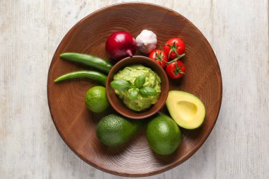 Lezzetli guacamole ve ahşap plaka üzerinde sebze ile kase