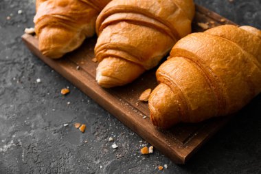 Gri dokulu arka plan üzerinde lezzetli kruvasan ile kurulu