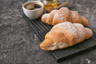 Gri dokulu arka plan üzerinde lezzetli kruvasan ile kurulu