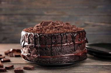 Ahşap masa üzerinde lezzetli çikolatalı kek ile plaka