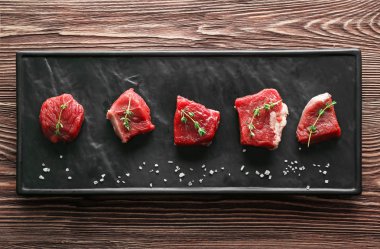 Plaka üzerinde baharatlar ile çiğ et parçaları