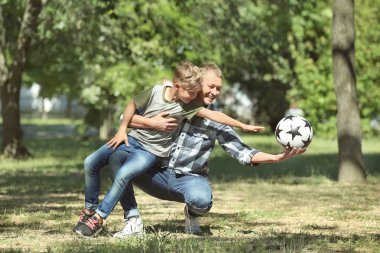 Mutlu baba ve oğul futbol topu parkta ile