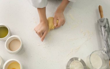 Kadın için mutfak masasında ekmek hamur yoğurma