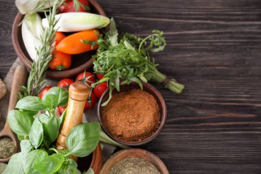 Ahşap arka plan üzerinde sebze ve otlar ile çeşitli baharatlar