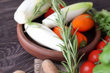 Taze sebze ve otlar ahşap masa üzerinde kase