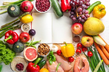 Işık arka plan üzerine açık not defteri ile çeşitli sağlıklı ürünler