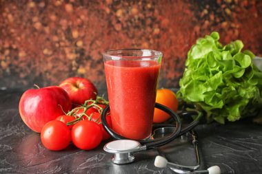 Bir bardak taze lezzetli smoothie malzemeler ve masada stetoskop ile. Sağlık kavramı