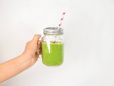 Mason kavanoza lezzetli smoothie ile beyaz arka plan üzerinde tutan el