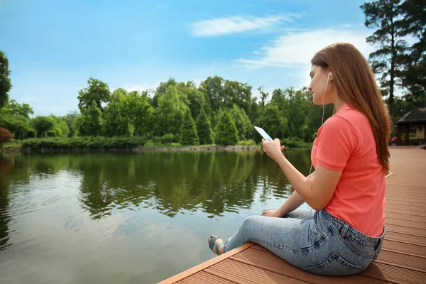 Young Woman Listening Music Wooden Bridge River — Stock Photo, Image