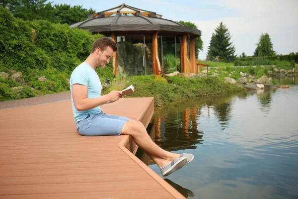Young Man Reading Book Wooden Bridge River — Stock Photo, Image