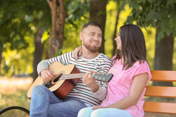 Mutlu çiftimiz parkta bahar gününde dinlenme gitar ile